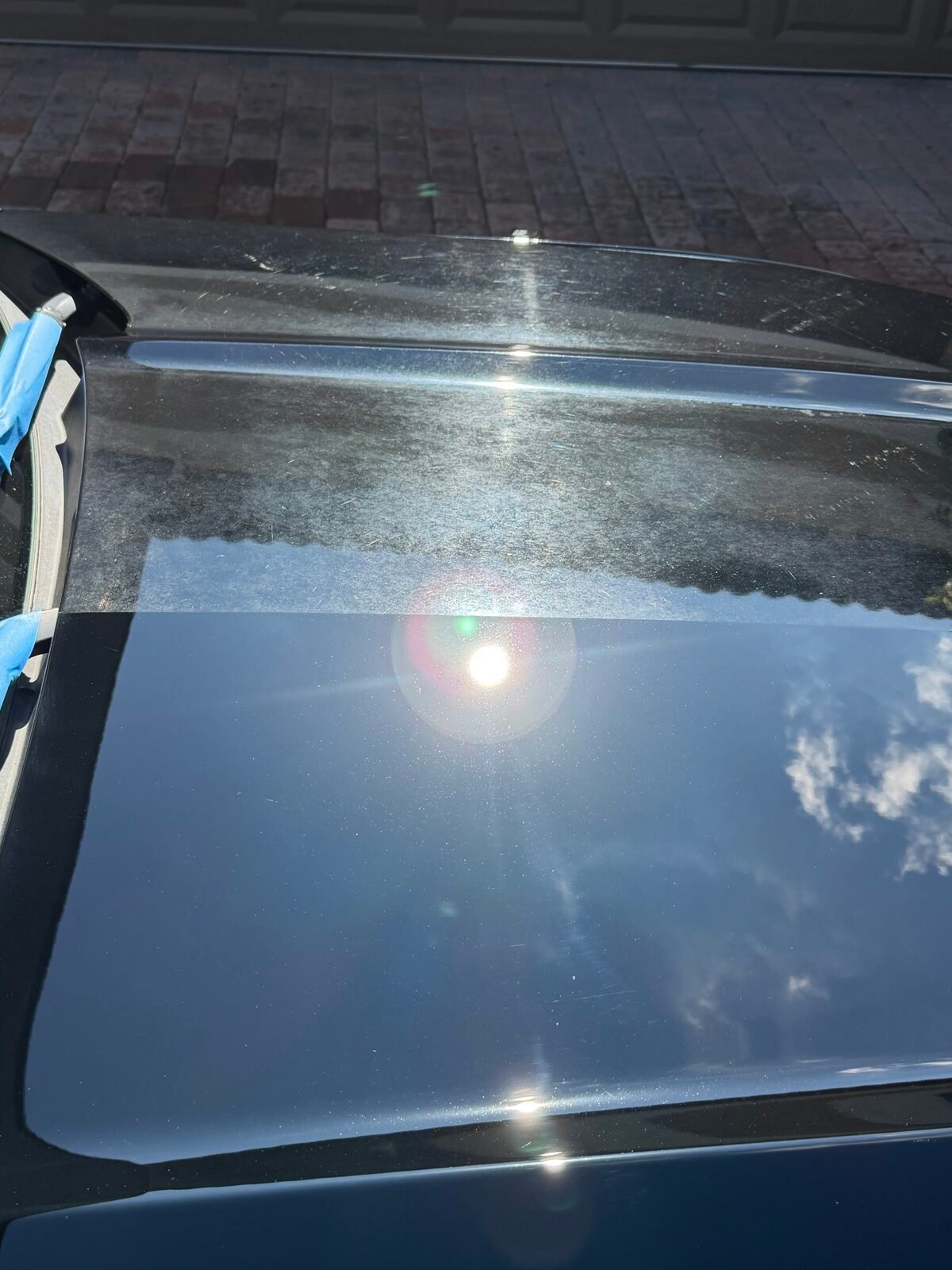 Real paint correction result on a black vehicle — top half shows swirl marks and oxidation, bottom half shows a deep, mirror-like finish after correction