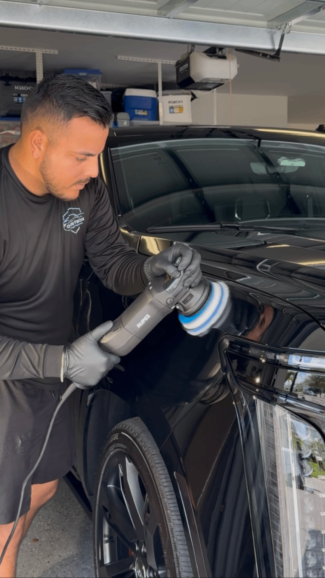 Yan, owner of Car Tech Mobile Detailing, polishing a black SUV in Sarasota